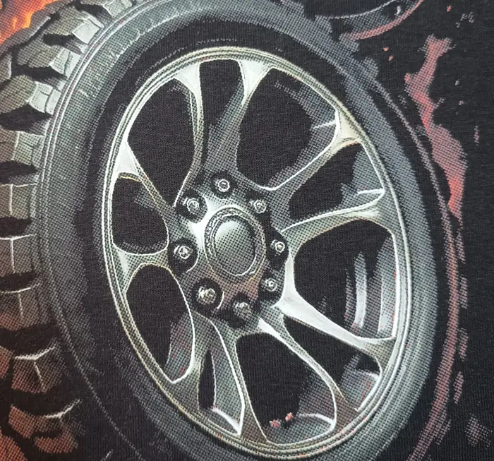 La même jante après pressage sur un chandail noir : entre les points d’encre, c’est le tissu noir du vêtement qui apparaît et forme les ombres.